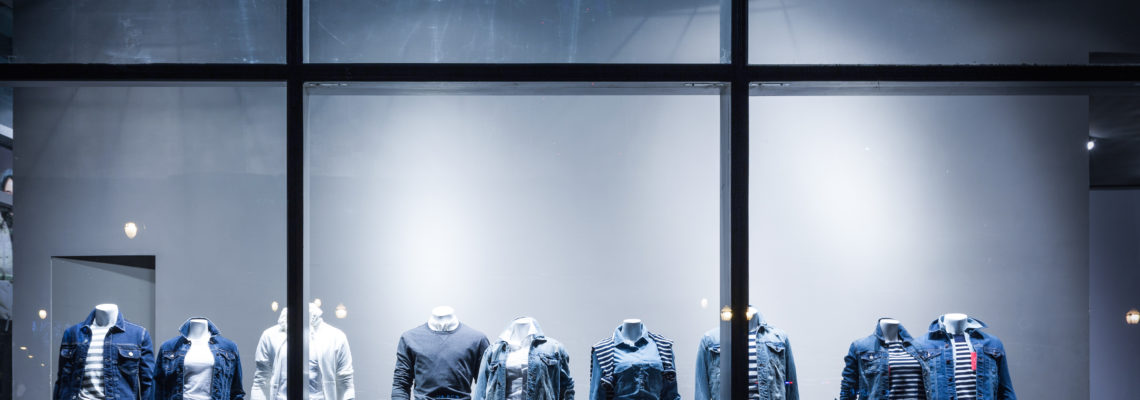 Click and Mortar Retail | Worldlink Integration Group | Clothing retail display window with mannequins in dim lighting at night