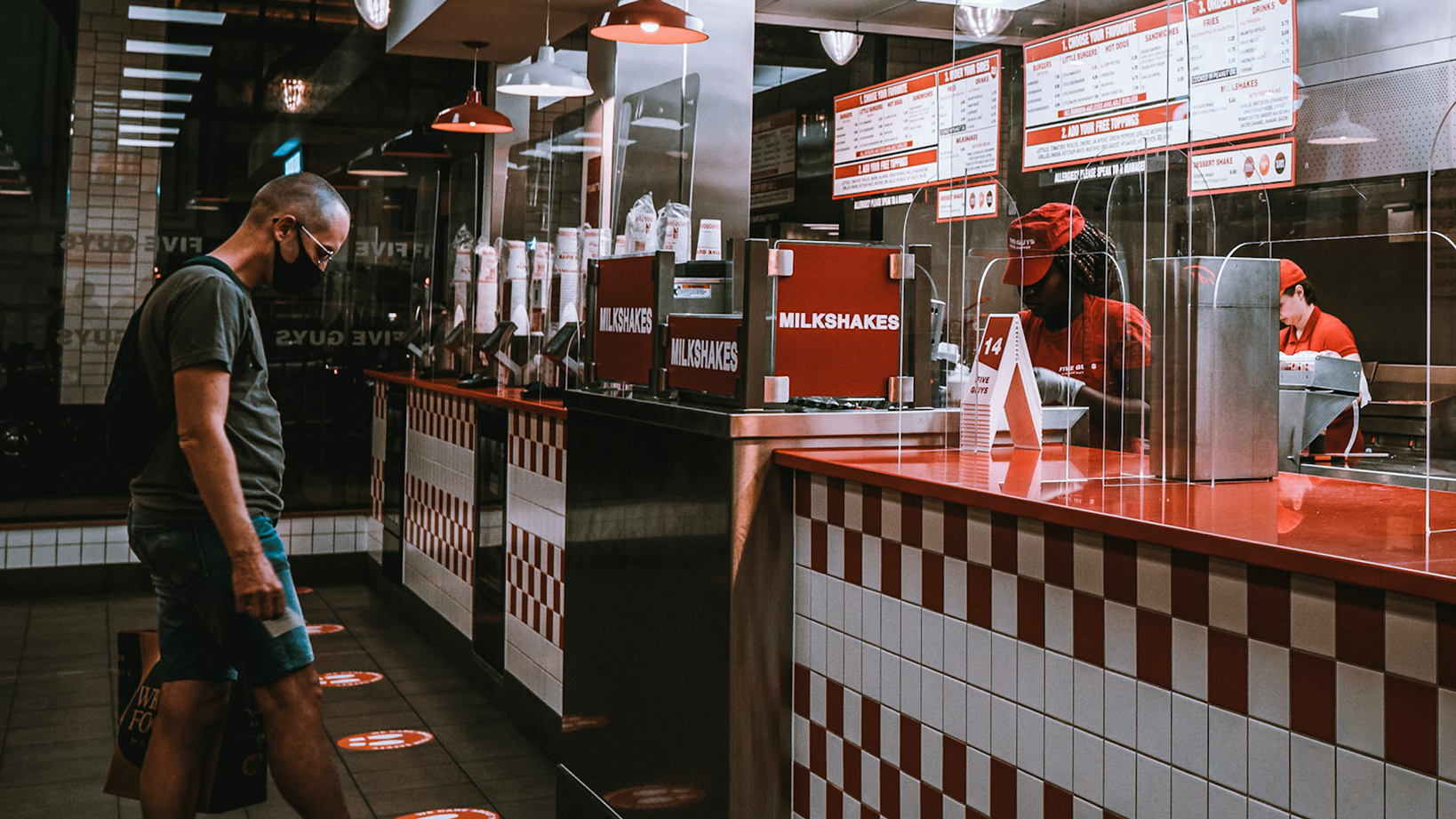 inside the fast-casual restaurant five guys where guy waits to pick up mobile order