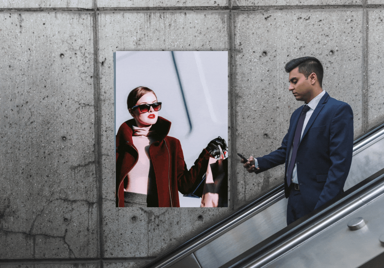 man passing digital signage advertisement in mall while on escalator